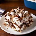 S’mores Lasagna: A No-Bake Dessert with Layers of Chocolate Pudding, Marshmallow Crème, and Graham Crackers This No-Bake S’mores Lasagna is a fun, layered dessert that brings all the flavors of a classic campfire s’more into a creamy, indulgent treat. With rich chocolate pudding, fluffy marshmallow crème, and crunchy graham crackers, it’s the ultimate dessert for parties, potlucks, or cozy nights in. Best of all, it requires no baking, so it’s easy to whip up without heating up the kitchen! Ingredients Cooking spray 2 (3.9-oz) boxes instant chocolate pudding 3 1/2 cups whole milk 1/4 cup dark or Dutch-process cocoa powder 2 (7.5-oz) jars marshmallow crème 2 (8-oz) blocks cream cheese, softened 2 sleeves graham crackers, plus 1/2 cup lightly crushed for topping 4 1/2 cups mini marshmallows, divided 2 cups dark chocolate chips 1 (16-oz) container Cool Whip 1/4 cup hot fudge sauce 2 Hershey's bars, broken into small pieces Directions Step 1: Prepare the Pudding and Marshmallow Mixture Spray a 9"x13" baking dish with cooking spray to prevent sticking. In a large mixing bowl, whisk together the chocolate pudding mix, whole milk, and cocoa powder until smooth and well-combined. Set aside. In a separate bowl, beat the marshmallow crème and softened cream cheese together with an electric mixer until fully smooth and combined. This mixture should be light and fluffy. Step 2: Layer the Ingredients Place a single layer of graham crackers at the bottom of the prepared baking dish, breaking them as needed to fit. Spread half of the marshmallow crème mixture evenly over the graham crackers. Sprinkle 2 cups of mini marshmallows on top of the marshmallow layer. Next, spread half of the chocolate pudding mixture over the mini marshmallows, using a spatula to smooth it evenly. Repeat the layers with another layer of graham crackers, the remaining marshmallow mixture, another 2 cups of mini marshmallows, and the remaining chocolate pudding. Sprinkle the dark chocolate chips over the final pudding layer for added chocolatey goodness. Step 3: Chill the Dessert Cover the baking dish with plastic wrap or foil and refrigerate for at least 2 hours, or until cold and set. This chilling time allows the layers to meld together and the graham crackers to soften slightly, creating a deliciously creamy texture. Step 4: Top and Serve Once the dessert is set, remove it from the refrigerator. Spread the Cool Whip evenly over the top layer of chocolate pudding. Warm the hot fudge sauce in the microwave until it is pourable but not too hot, then drizzle over the Cool Whip layer for an extra layer of indulgence. For the finishing touch, top with crushed graham crackers, Hershey’s bar pieces, and the remaining mini marshmallows. Slice into squares and serve! Serving Suggestions This S’mores Lasagna is a deliciously indulgent dessert that’s easy to serve at any event. Its creamy layers make it fun to scoop and serve in small squares. For a complete s’mores experience, lightly torch the top marshmallows (if desired and safe) to bring out that classic toasted flavor! Serving and Storage Tips Serving Size: This recipe makes about 12 servings, perfect for sharing. Storage: Keep any leftovers in the refrigerator, covered, for up to 3 days. Make-Ahead Tip: This dessert actually tastes better after it has chilled for several hours, so it’s great to prepare a day in advance. Helpful Notes Pudding Consistency: Be sure to use instant pudding mix, as cook-and-serve pudding may not set properly in a no-bake recipe. Alternative Layers: You can use chocolate graham crackers or add a layer of crushed Oreos for extra crunch and flavor. Cool Whip Substitute: If you prefer, whipped heavy cream can be used in place of Cool Whip, though it’s best whipped to medium peaks for this recipe. Tips from Well-Known Chefs Chef Duff Goldman suggests using high-quality dark chocolate for a more intense flavor in no-bake desserts. Chef Ina Garten recommends adding a pinch of sea salt to the pudding mixture for a salted chocolate twist. Chef Christina Tosi suggests freezing the s’mores lasagna for a slightly firmer texture that makes slicing even easier. Frequently Asked Questions 1. Can I use homemade whipped cream instead of Cool Whip? Yes, homemade whipped cream can be substituted. Whip heavy cream with a little sugar until medium peaks form and use in place of Cool Whip. 2. What if I don’t have marshmallow crème? If marshmallow crème isn’t available, you can melt marshmallows with a little butter on the stovetop until smooth, then let cool before mixing with the cream cheese. 3. Can I make this dessert gluten-free? Yes, use gluten-free graham crackers for a gluten-free version. The other ingredients are typically gluten-free. 4. How long can I keep leftovers? Leftovers can be stored in the refrigerator for up to 3 days. The graham crackers will continue to soften, so it’s best enjoyed within the first couple of days. 5. Can I freeze S’mores Lasagna? Yes, you can freeze it for up to 1 month. Thaw in the refrigerator for several hours before serving. 6. Can I use regular milk instead of whole milk? Whole milk provides the best creamy texture for the pudding, but you can use 2% milk if needed. Avoid using skim milk as it may result in a thinner consistency. 7. Can I add more chocolate? Absolutely! Try adding chopped chocolate or more chocolate chips between the layers for an even richer dessert. 8. Do I need to let the dessert set before serving? Yes, chilling for at least 2 hours helps the layers set, which gives it the creamy texture and structure when sliced. 9. Can I toast the marshmallows on top? Yes, carefully use a kitchen torch to lightly toast the top layer of marshmallows for that classic s’mores flavor. 10. Can I make this in individual servings? Yes! Layer the ingredients in small mason jars or dessert cups for individual servings that are great for parties or picnics. This No-Bake S’mores Lasagna is the ultimate summer or party dessert, offering layers of chocolatey, marshmallow goodness with a satisfying crunch of graham crackers. Enjoy every sweet, creamy bite!